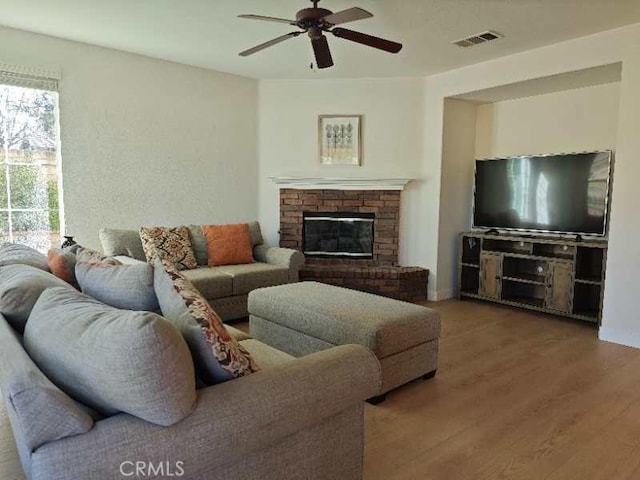 living room featuring a fireplace, ceiling fan, and hardwood / wood-style floors