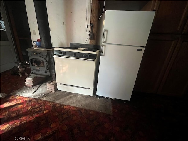 kitchen featuring white appliances, washer / clothes dryer, and a wood stove