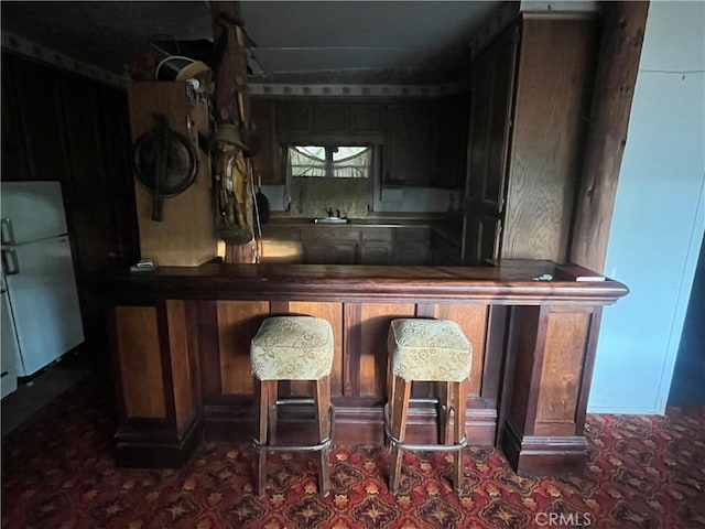 bar with a bar and freestanding refrigerator