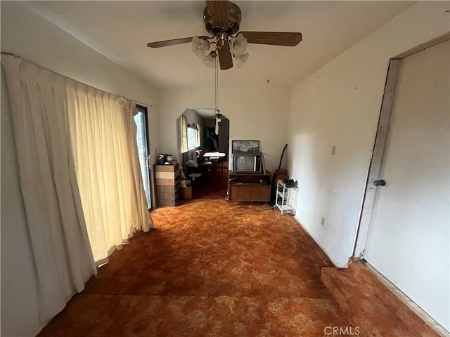 office space featuring arched walkways and ceiling fan