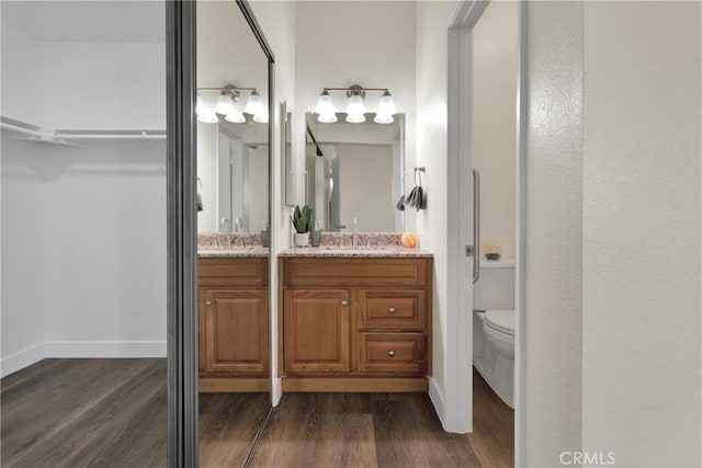 bathroom featuring toilet, vanity, and hardwood / wood-style floors