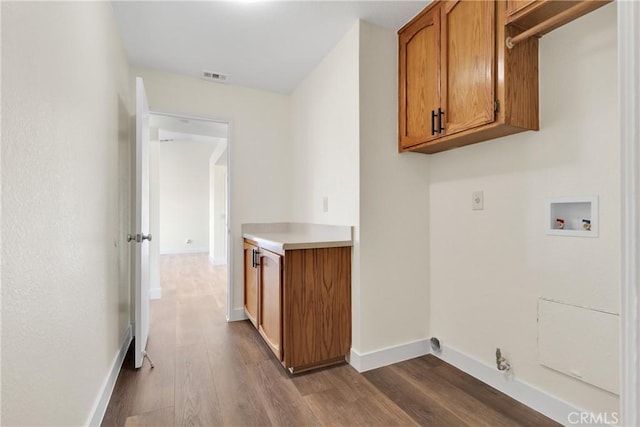 clothes washing area with light wood-type flooring, cabinets, and washer hookup