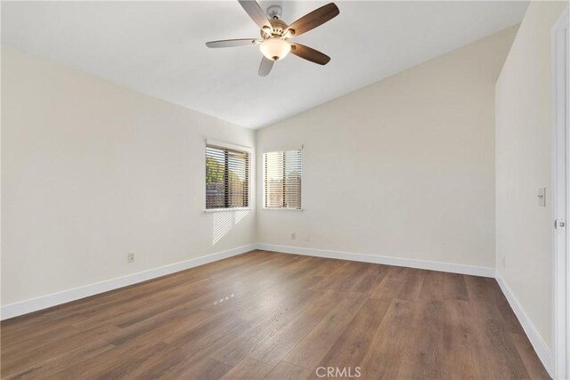 empty room featuring ceiling fan, vaulted ceiling, and dark hardwood / wood-style floors