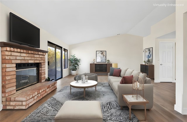 living room with lofted ceiling, a fireplace, and hardwood / wood-style floors