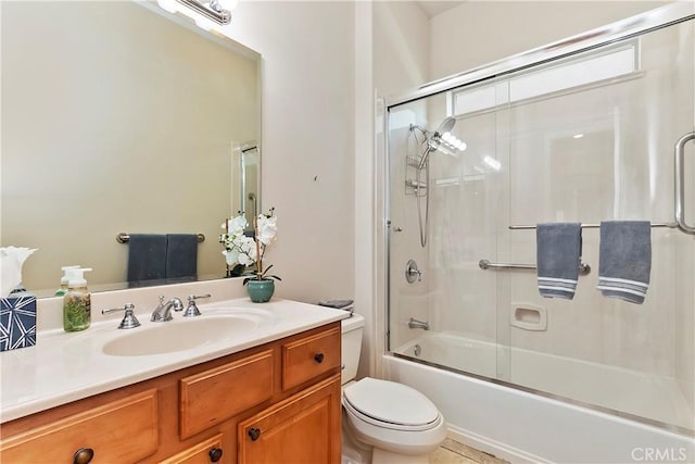 full bathroom featuring enclosed tub / shower combo, vanity, and toilet