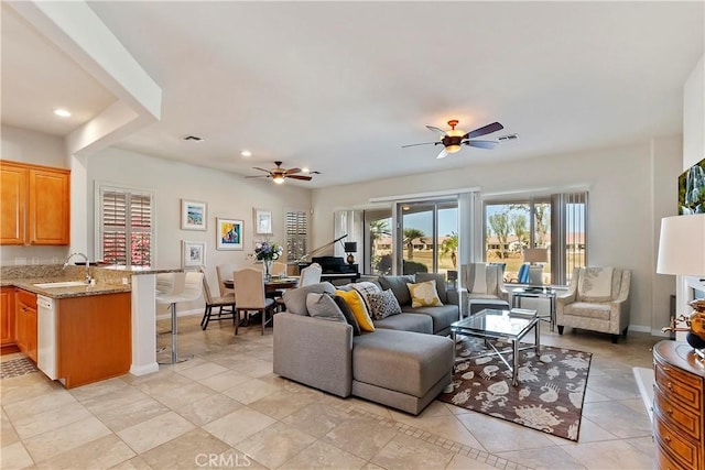 living room featuring ceiling fan, sink, and light tile patterned floors