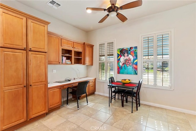 kitchen with built in desk, light tile patterned floors, and ceiling fan