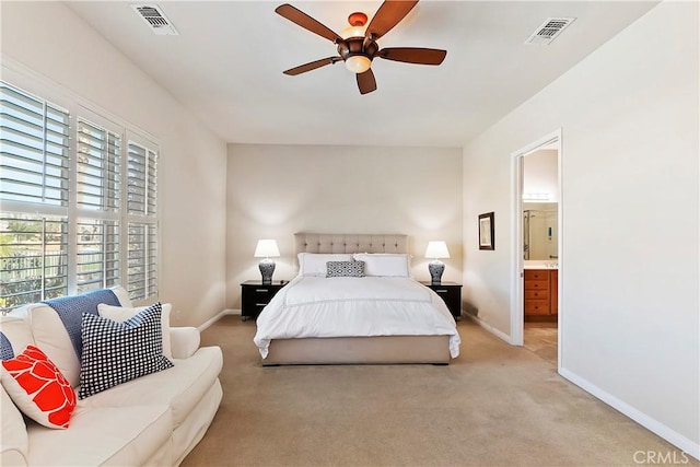 bedroom featuring ceiling fan, connected bathroom, and light carpet