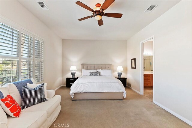 bedroom featuring ceiling fan, connected bathroom, and light carpet