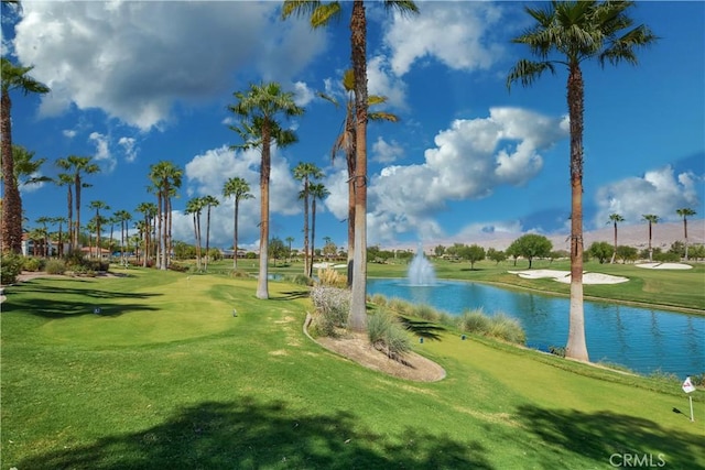 view of property's community with a water view and a lawn