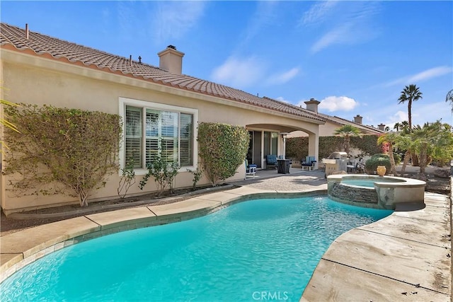 view of swimming pool featuring a patio and an in ground hot tub