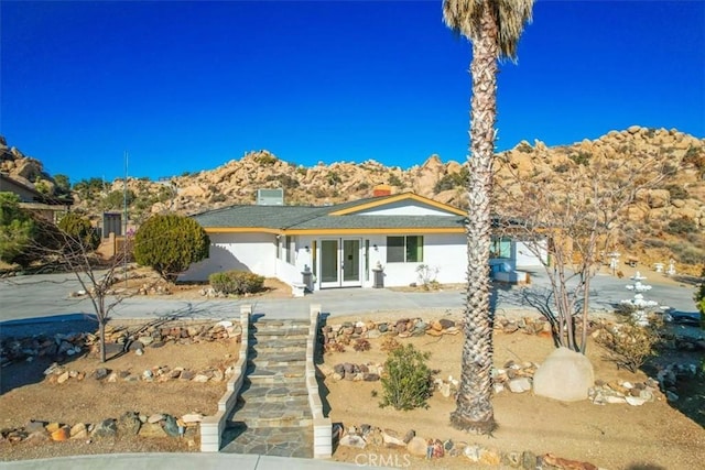 view of front of property with a mountain view and a patio area