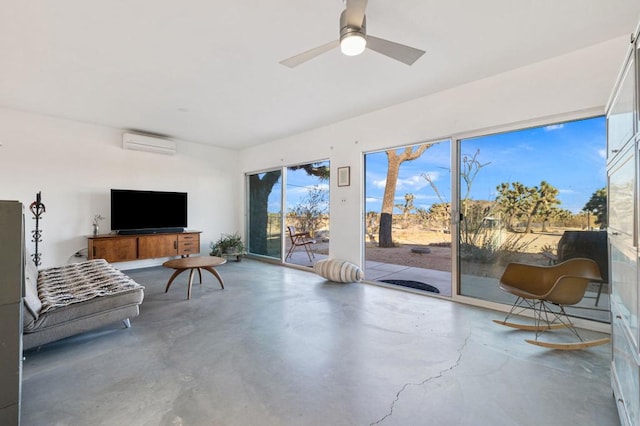 sitting room featuring a wall mounted air conditioner, concrete flooring, and ceiling fan