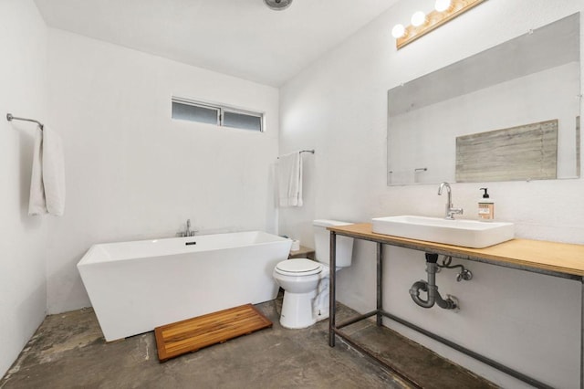 bathroom with a tub to relax in, sink, concrete flooring, and toilet