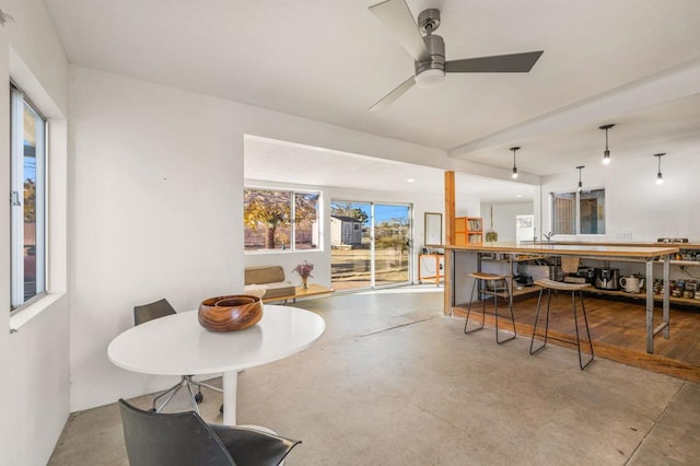 dining area with concrete floors and ceiling fan