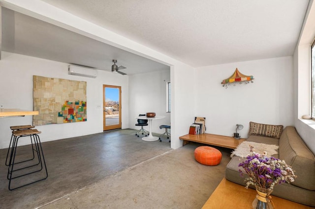 living room featuring ceiling fan, concrete floors, and a wall mounted air conditioner