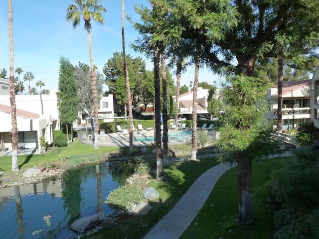 surrounding community featuring a yard, a water view, and a pool