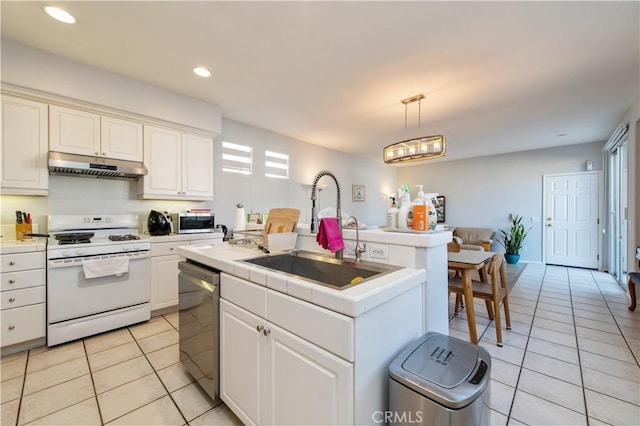 kitchen featuring a center island with sink, sink, light tile patterned floors, decorative light fixtures, and stainless steel appliances