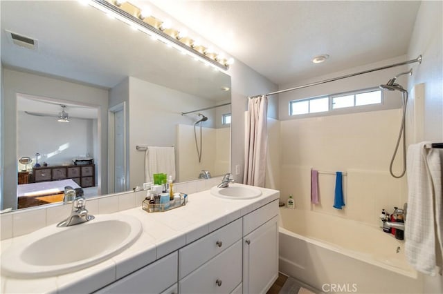 bathroom with vanity, shower / bathtub combination with curtain, and ceiling fan