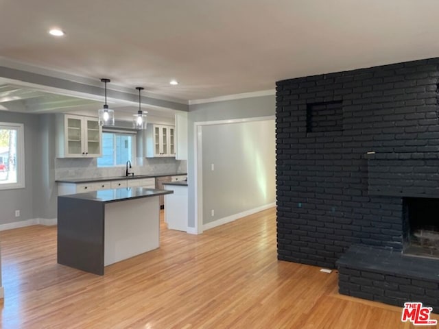 kitchen with pendant lighting, white cabinetry, decorative backsplash, and light wood-type flooring