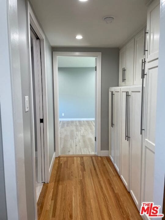 hallway with light hardwood / wood-style floors