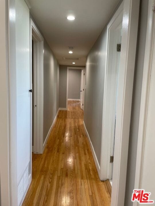 corridor with light hardwood / wood-style floors