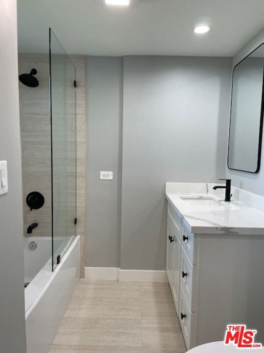 bathroom featuring tiled shower / bath combo and vanity