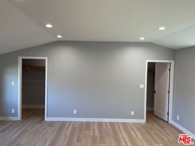 unfurnished room featuring light hardwood / wood-style flooring and vaulted ceiling