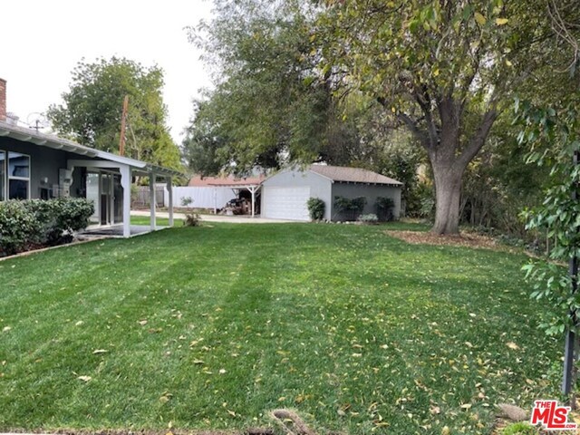 view of yard with a garage and an outbuilding