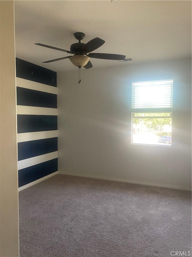 spare room with ceiling fan, carpet flooring, and visible vents