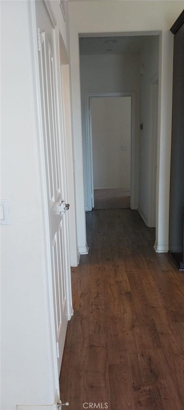 corridor featuring dark wood finished floors