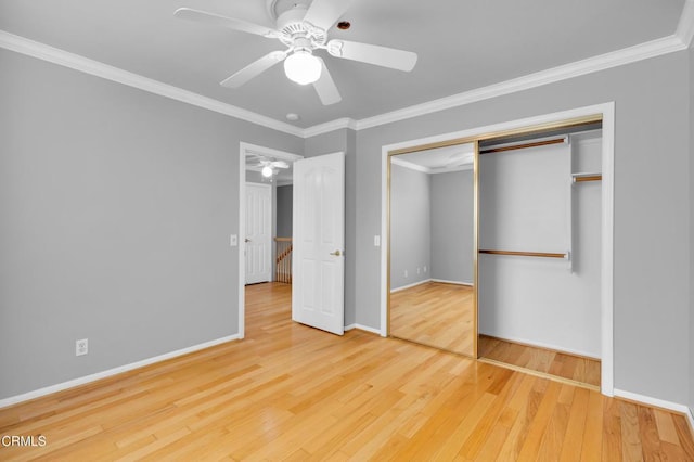 unfurnished bedroom with crown molding, a closet, ceiling fan, and wood-type flooring