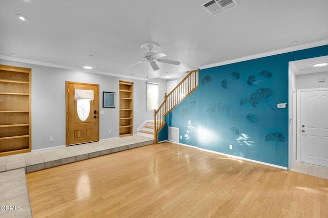 interior space with hardwood / wood-style flooring, ceiling fan, built in features, and ornamental molding