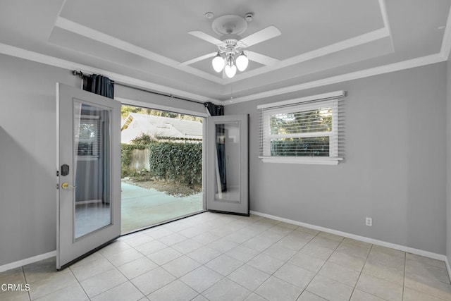 tiled empty room with a raised ceiling, ceiling fan, and french doors