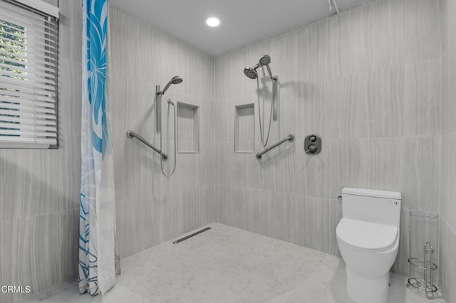 bathroom featuring a shower with curtain, toilet, and tile walls