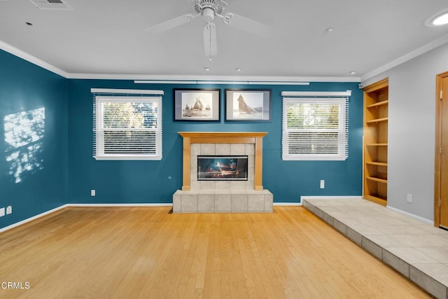 unfurnished living room featuring a fireplace, light hardwood / wood-style flooring, a wealth of natural light, and crown molding