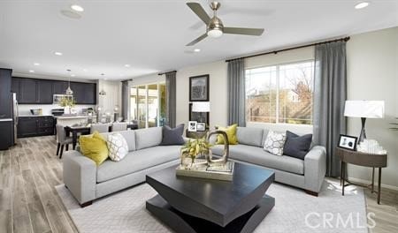 living room with ceiling fan and light hardwood / wood-style floors