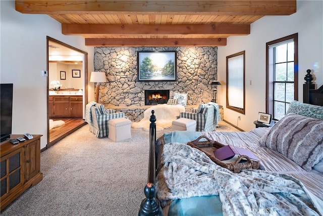 bedroom with carpet flooring, a stone fireplace, wooden ceiling, and beamed ceiling