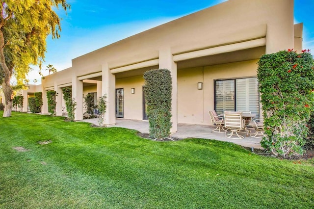 back of house featuring a yard and a patio area