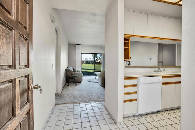 kitchen with white cabinetry, dishwasher, light colored carpet, and sink