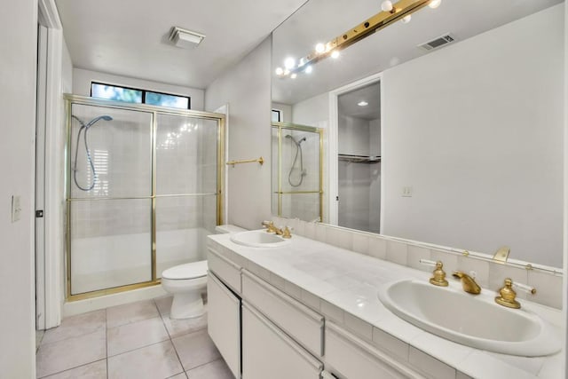 bathroom with toilet, vanity, tile patterned floors, and an enclosed shower