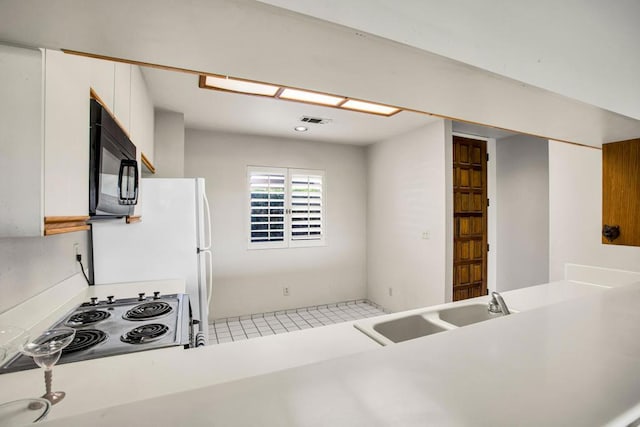 kitchen with white cabinets, range, and sink