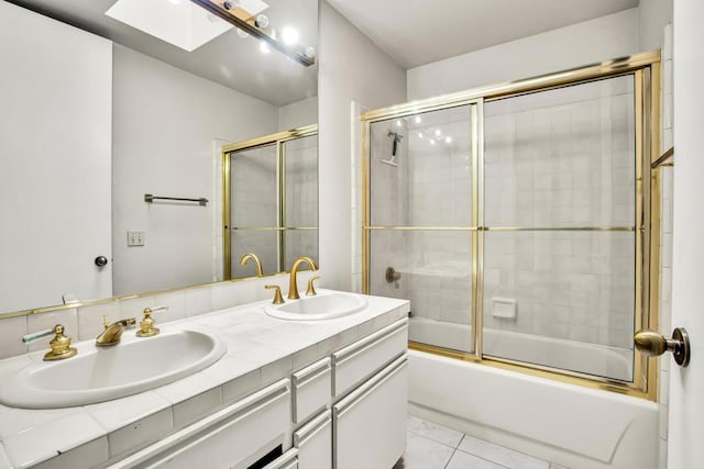 bathroom with vanity, a skylight, tile patterned floors, and enclosed tub / shower combo