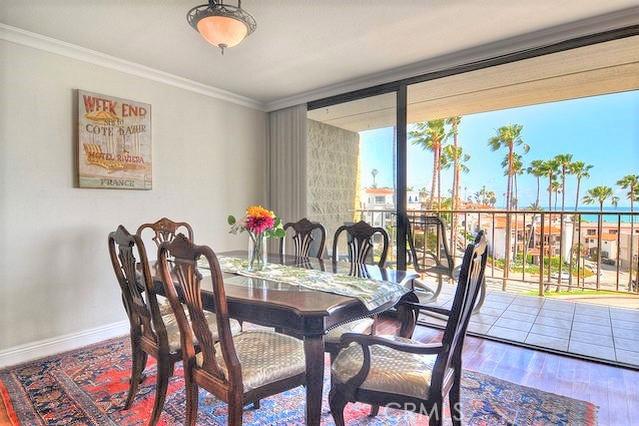 dining area featuring crown molding, baseboards, and wood finished floors