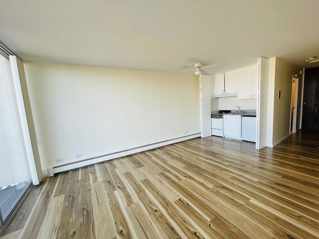 unfurnished living room featuring sink, ceiling fan, light hardwood / wood-style flooring, and a baseboard heating unit