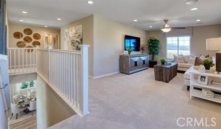 carpeted living room with ceiling fan