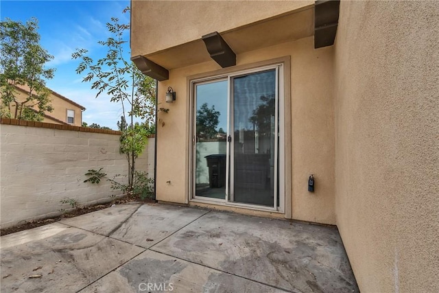 view of exterior entry featuring a patio area