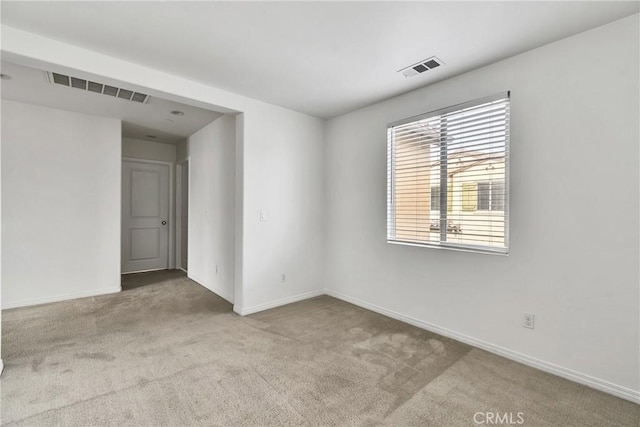 spare room featuring light colored carpet