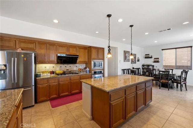 kitchen with appliances with stainless steel finishes, extractor fan, light tile patterned floors, decorative light fixtures, and a center island