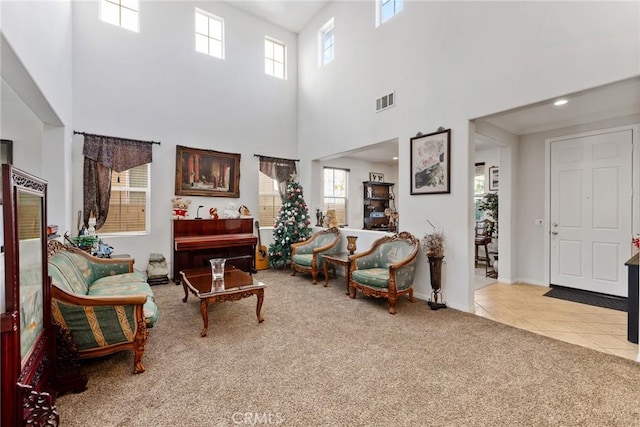 living room featuring carpet and a towering ceiling